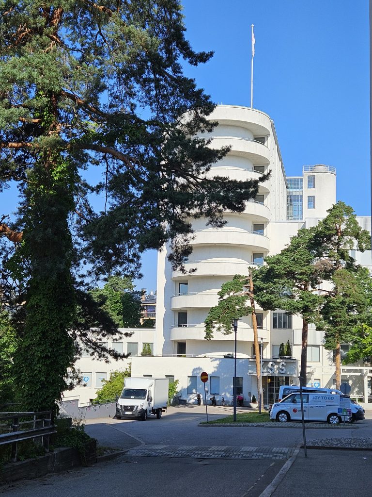 Streamlined corner façade of Tilkka Hospital in Helsinki, featuring horizontal windows and minimalist detailing — documented in 2025.