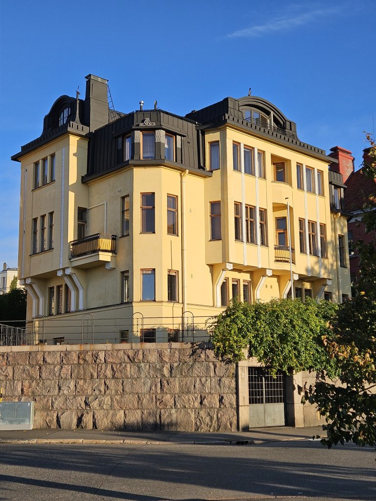 Residential corner building with bay windows and light-toned façade on Wecksellintie 2 in Eira, Helsinki — documented in 2025.